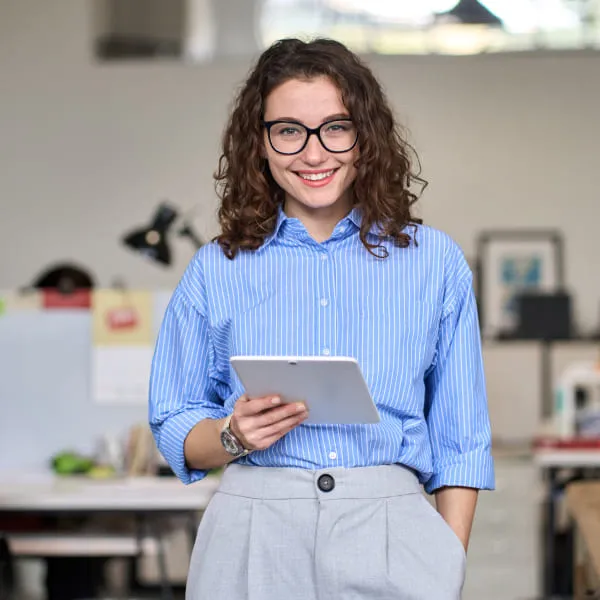 A woman in glasses holding a tablet computer.
